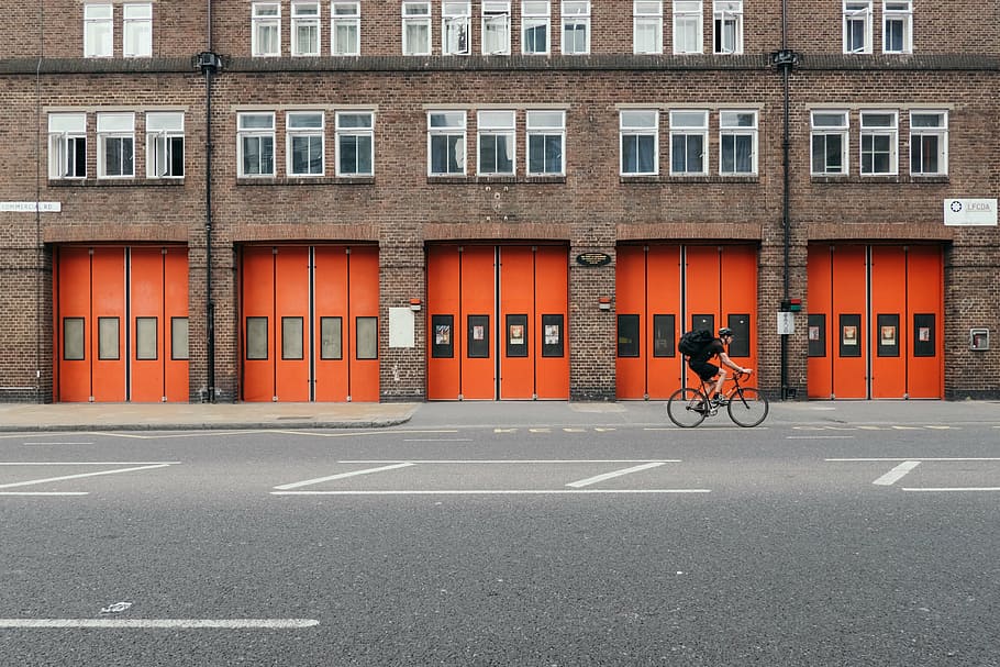 man, riding, bicycle, fire brigade, doors, gates, red, orange, department, firefighter