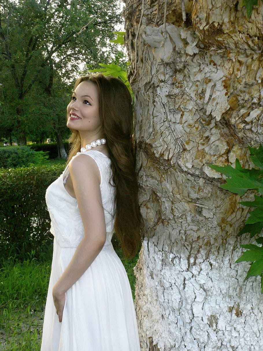 woman, white, sleeveless dress, looking, brown, tree trunk, woman in white, sleeveless, dress, looking up