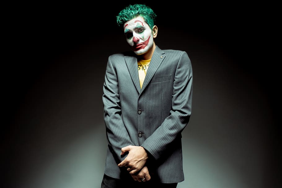 joker, makeup, guilty, sad, hand, suit, studio shot, one person, well-dressed, black background