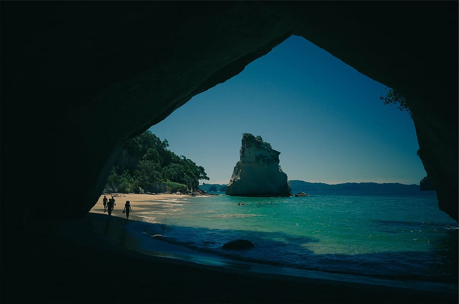Gente, monolito de roca, silueta, dos, persona, de pie, al lado, cueva, cerca, océano