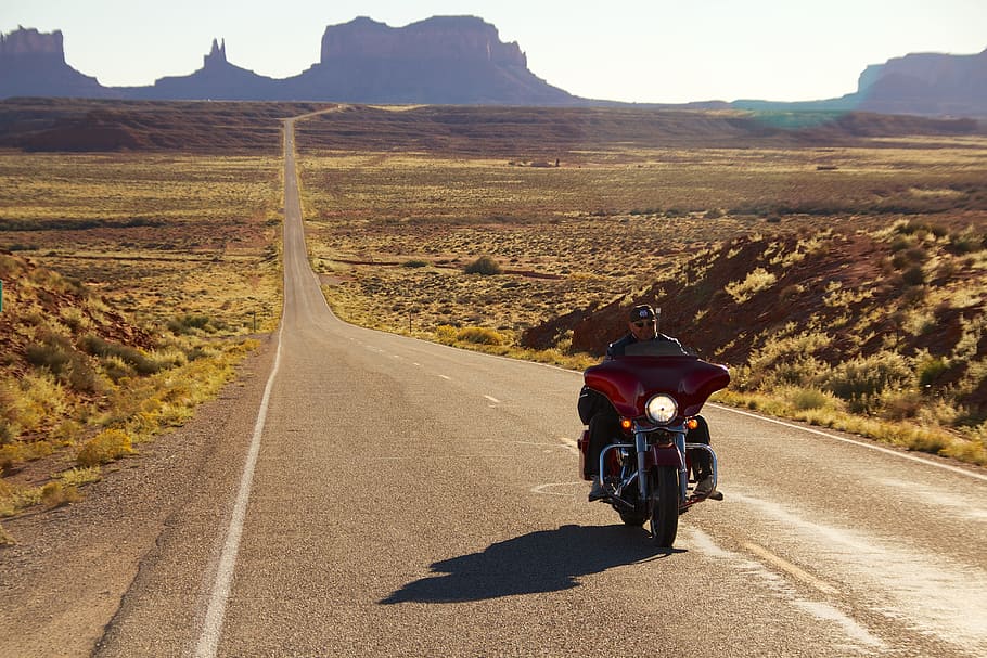 man, riding, red, touring, motorcycle, middle, road, daytime, monument valley, harley davidson
