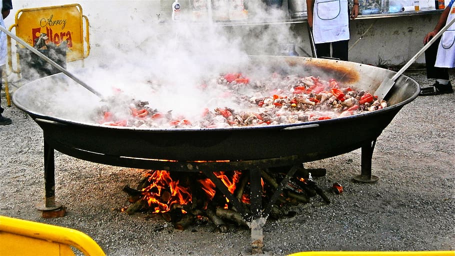 Persona cocinando plato de carne, wok, paella, arroz, comida, fiesta, España, calor - temperatura, quema, comida y bebida