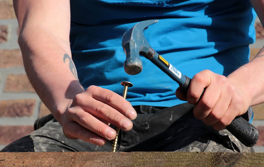 blue nailing hammer, wooden board, larch, screw, long screw, hammer, screw turn, fix, carpenter work, hands