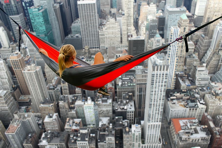 mulher, sentado, vermelho, rede, com vista, arranha-céus, edifícios, altura, corajoso, coragem
