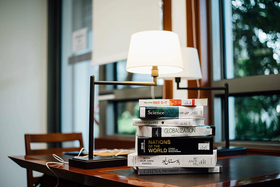 encendido, blanco, lámpara de mesa, al lado, surtido, libros, etiquetado, libro, dos, mesa