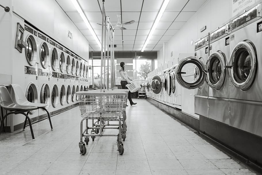laundry, laundromat, waching machines, dryers, carts, clothes, baskets, one person, washing machine, appliance