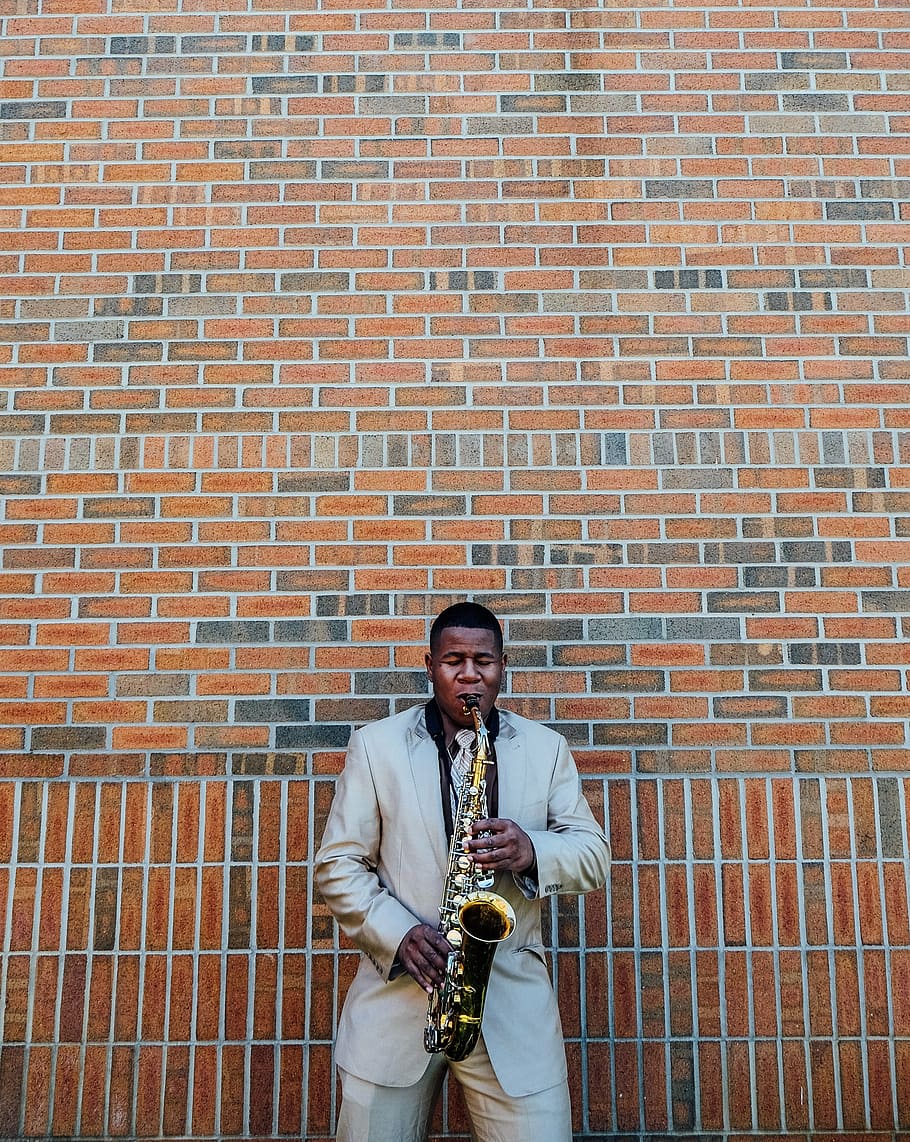man playing saxophone, people, man, music, saxophone, wind, instrument, tuxedo, formal, bricks