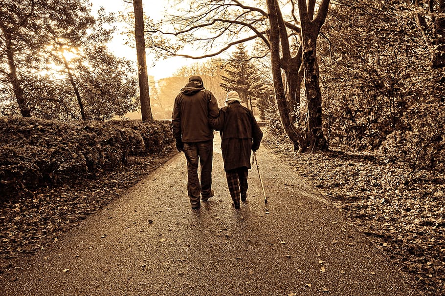 pareja, caminando, a lo largo, concreto, camino, personas, ancianos, bastón blanco, del brazo, caminando del brazo