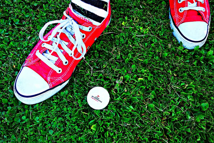 pessoa, mostrando, par, vermelho, conversar, tênis, pé, em pé, grama, bola de golfe