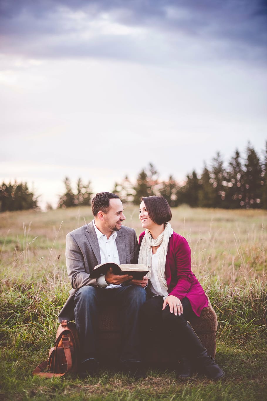 man, woman, sitting, grass fields, daytime, couple, stool, reading, books, people