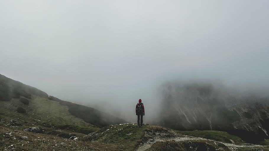 person, standing, front, mountains, foggy, day, field, guy, man, male