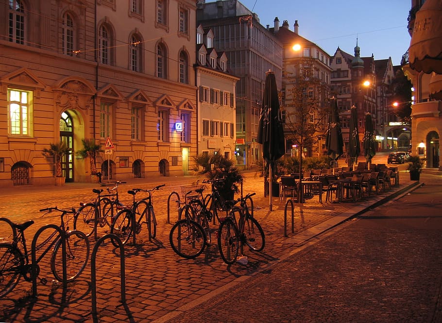 gray, bicycles park, green, patio umbrella, nighttime, freiburg, city, germany, road, homes