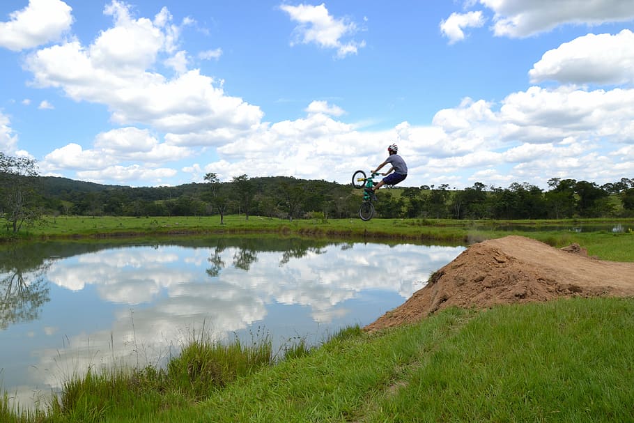 pond, bike, fun, radical, cloud - sky, sky, one person, plant, jumping, mid-air