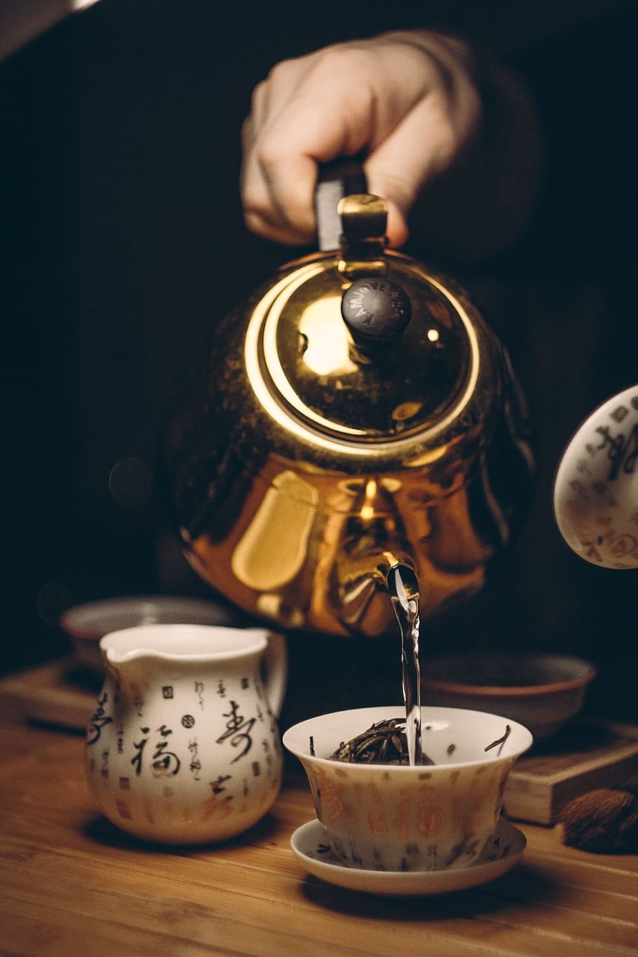 person, holding, brass kettle, white, teacup, saucer, beverage, breakfast, caffeine, cup