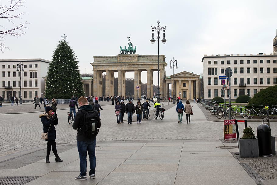 brandenburg gate, berlin, historic edifice, pedestrians, students, tourists, ornate lamp posts, street furniture, christmas tree, architecture