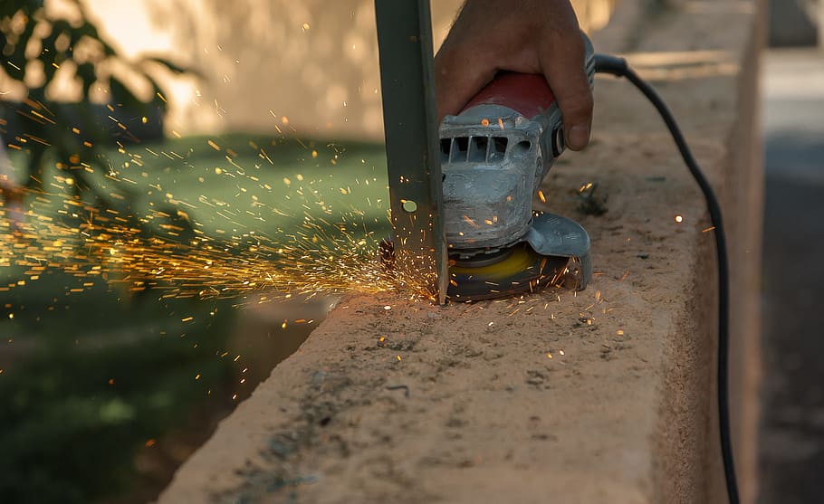 person, cutting, gray, metal, using, corded, angle grinder, tool, grinder, sparks