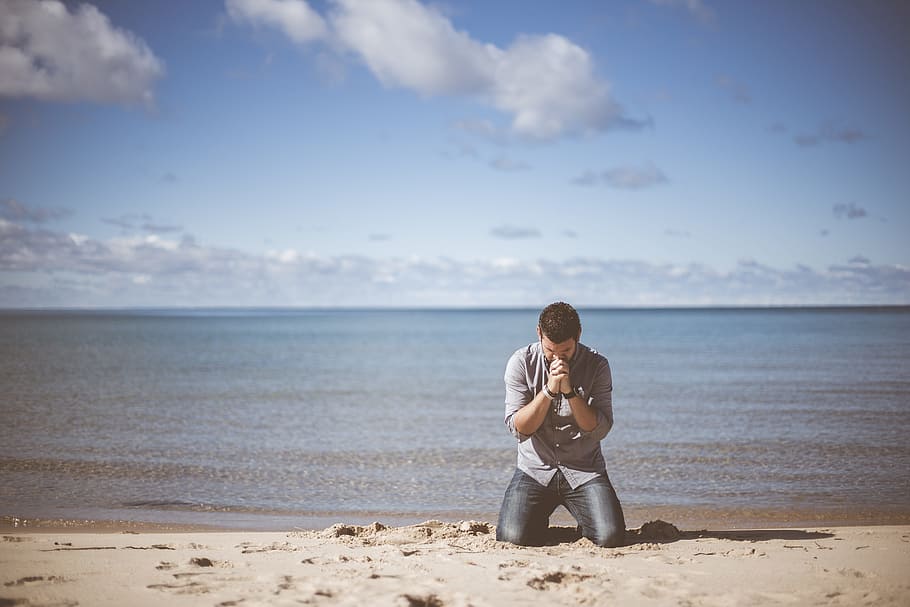 man, wearing, grey, shirt, kneeling, beach shore, praying, cloudy, sky, beach
