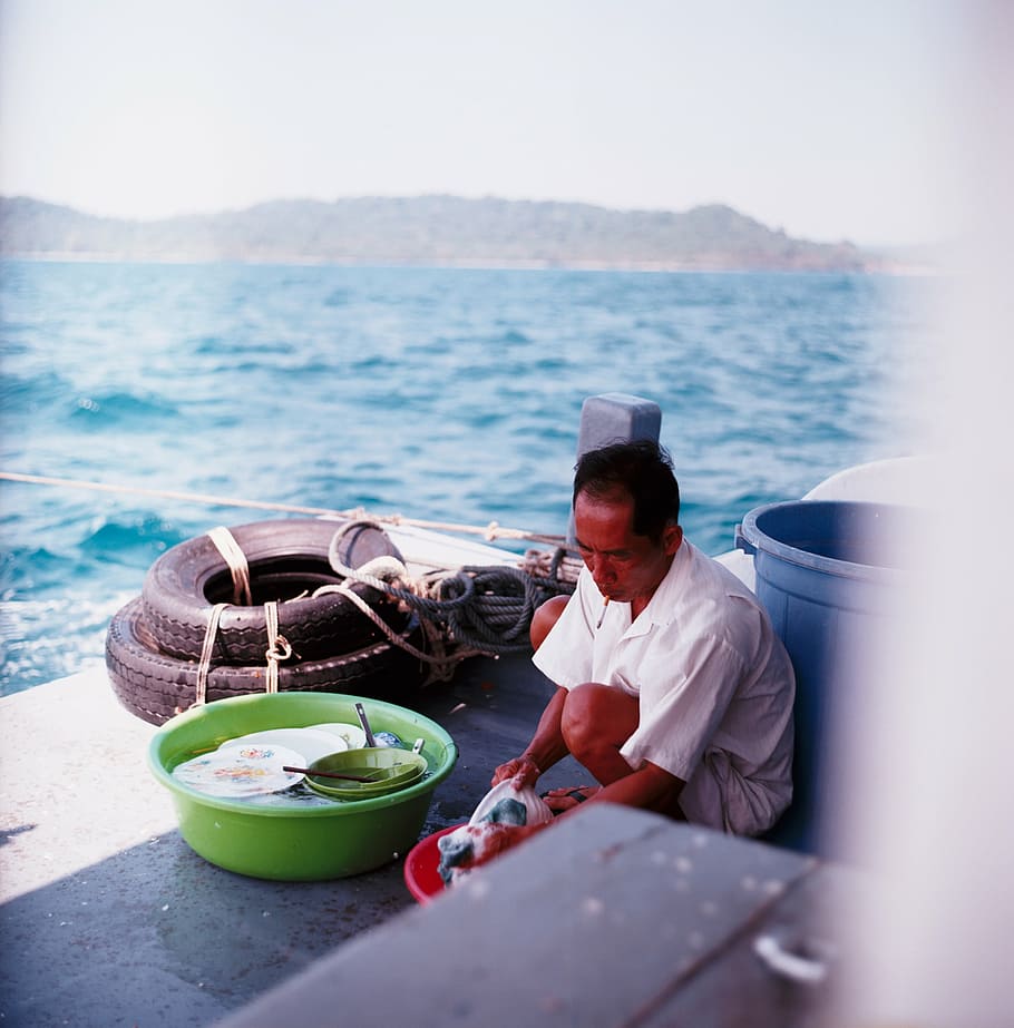 man, sitting, cleaning clothes, sea, people, dishwasher, plate, boat, yacht, tire