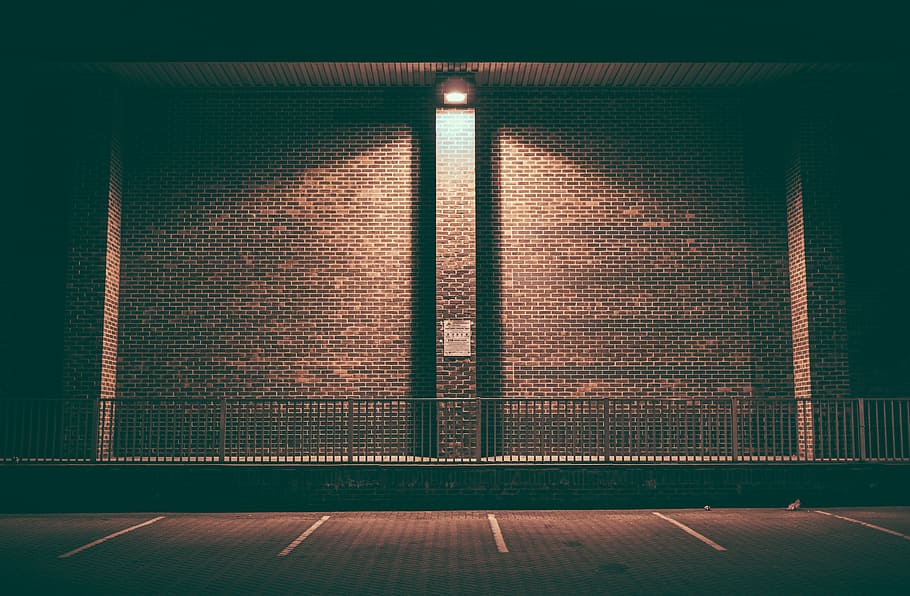 muro de hormigón marrón, pared de ladrillo, vacío, iluminado, noche, área de estacionamiento, espacio de estacionamiento, lugares de estacionamiento, patrón, barandilla de acero