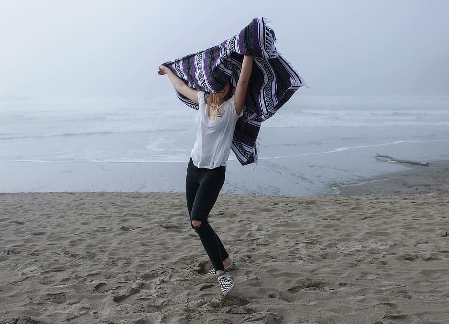 smiling, woman dancing, seashore, daytime, woman, wearing, white, shirt, holding, purple