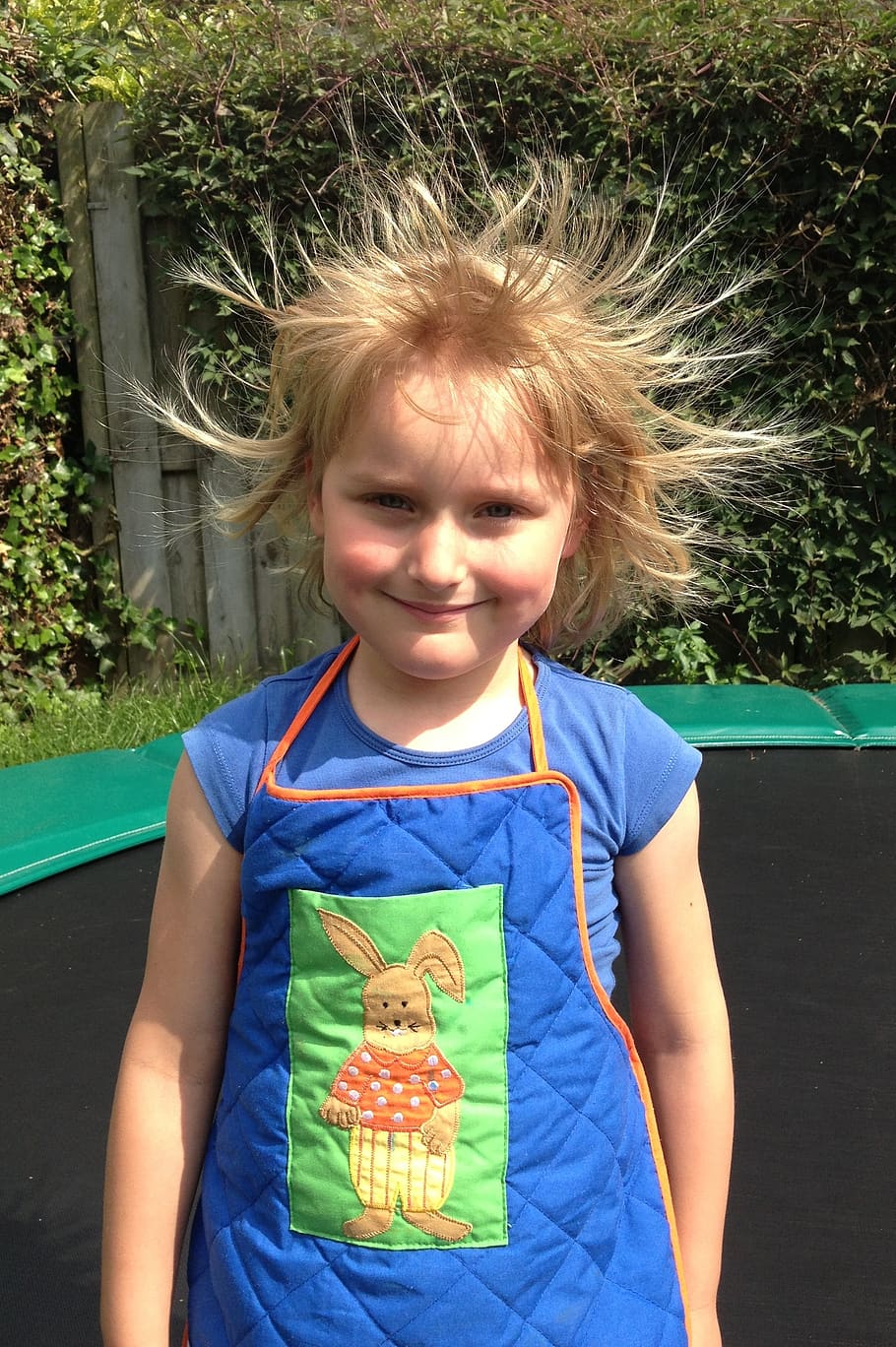 girl, child, trampoline, blonde, static electricity, electricity, childhood, front view, smiling, looking at camera