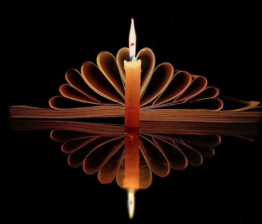 candle, lowlight, yellow, book, pattern, reflection, light, flame, black background, studio shot
