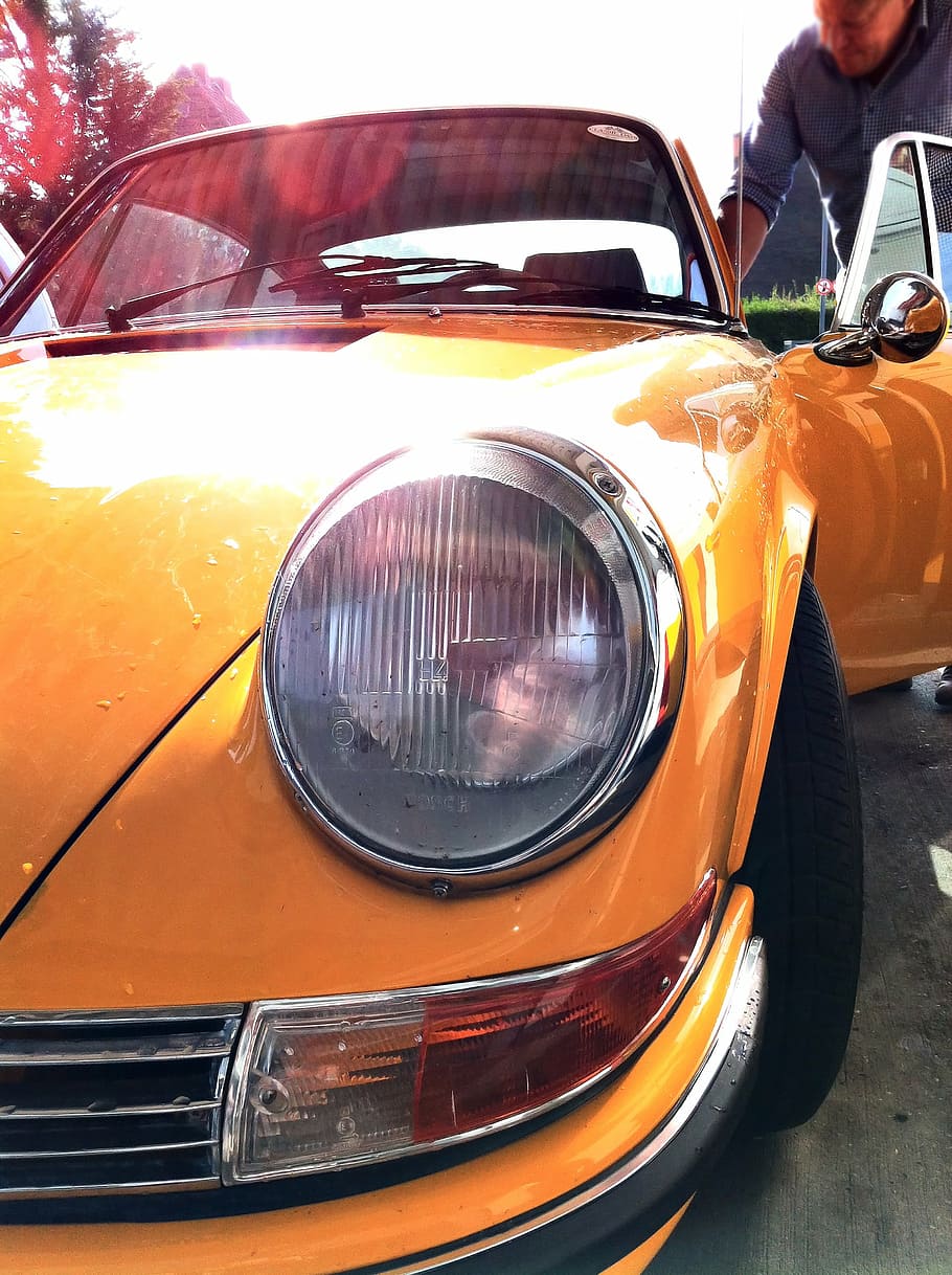 man, getting, inside, vintage, yellow, porsche coupe, automobile, car, close up, headlights