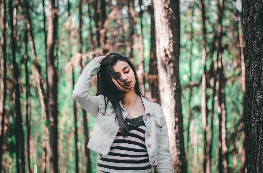 mulher, segurando, cabelo, em pé, árvores, cinza, botão, jaqueta, meio, bosques