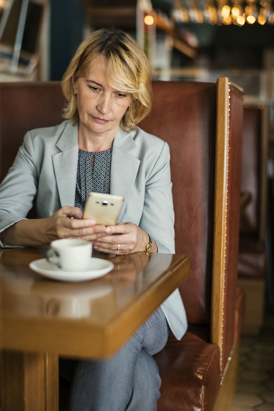 woman, holding, smartphone, sitting, chair, table, american, bs, business, businesswoman