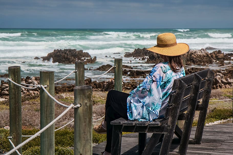 person, wearing, brown, hat, seating, wooden, chair, woman sitting, seaside, rocks