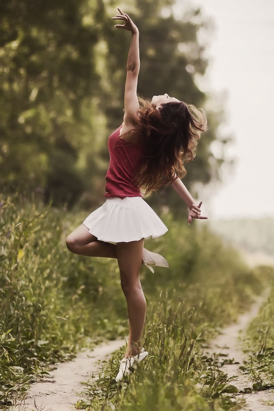 woman, pink, top, white, pleated, mini skirt, dance gesture, grass, covered, pathway