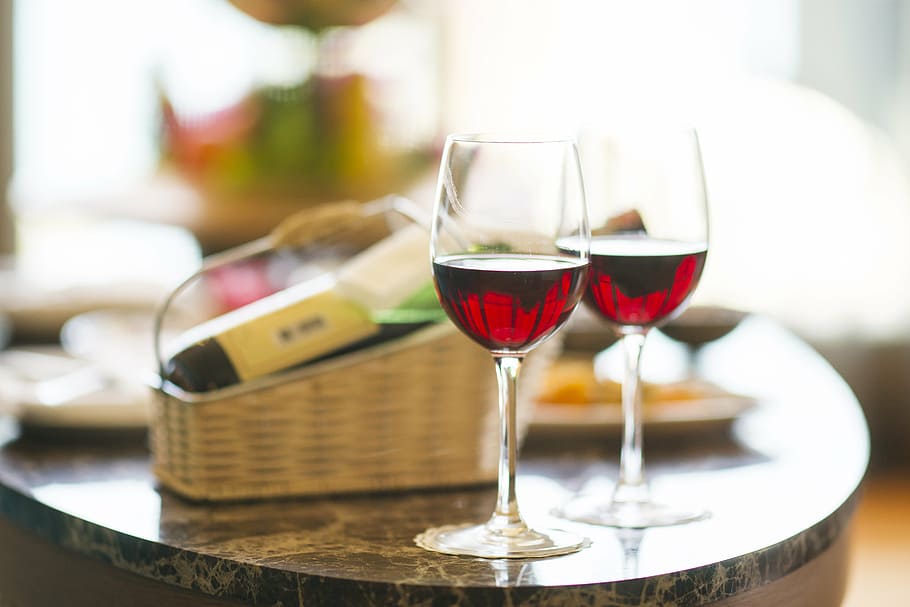dois, copos de vinho, preenchido, vinho, vermelho, jantar, hotel, férias, celebração, feliz