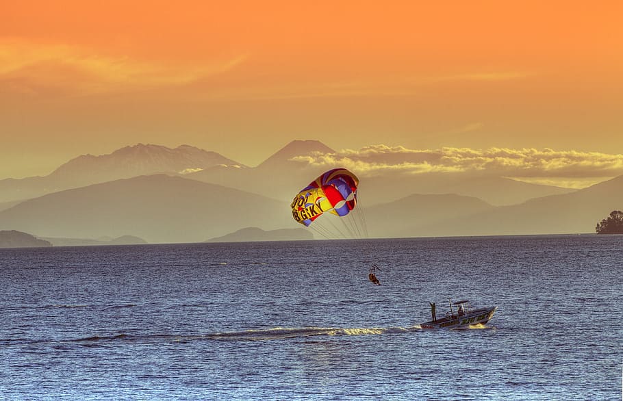 person parasailing, dusk, lake taupo, new zealand, north island, boat, sunset, volcano, parachute, fun