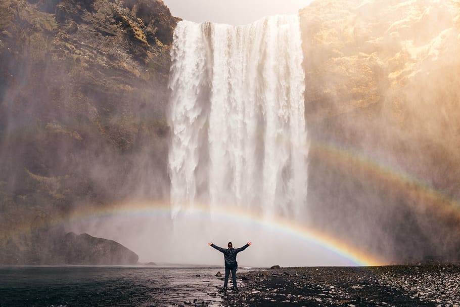 person, standing, front, waterfall, daytime, rainbow, spray, water, flow, cascade