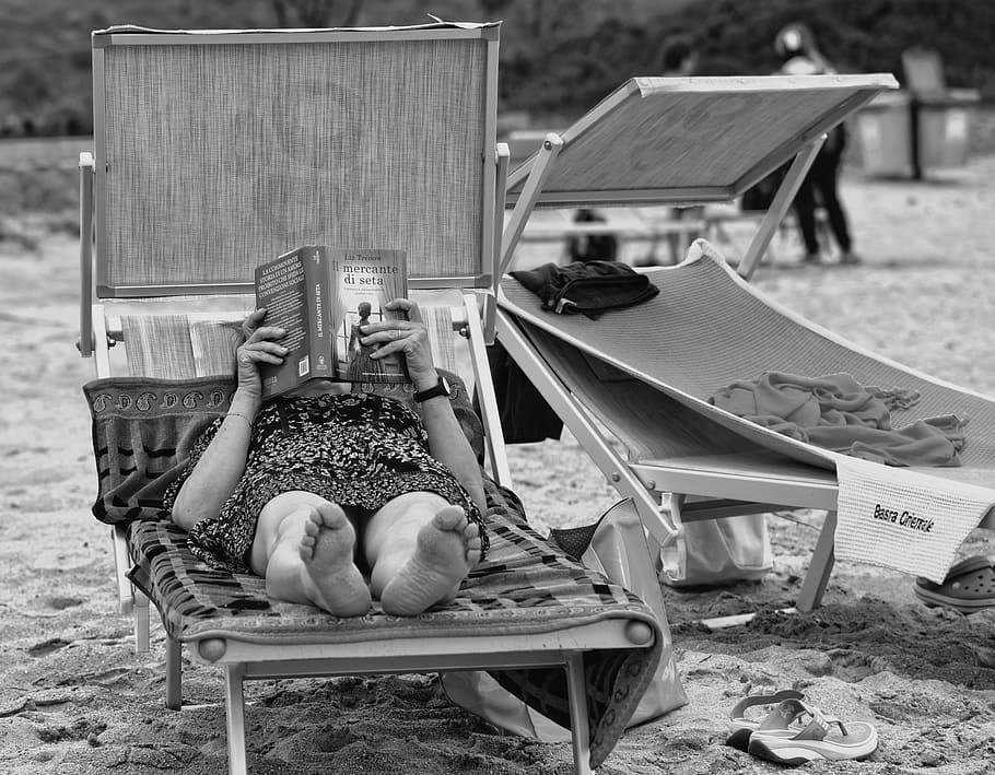 grayscale photography, woman, bed, person, people, reading, book, lying down, reclining, beach chair