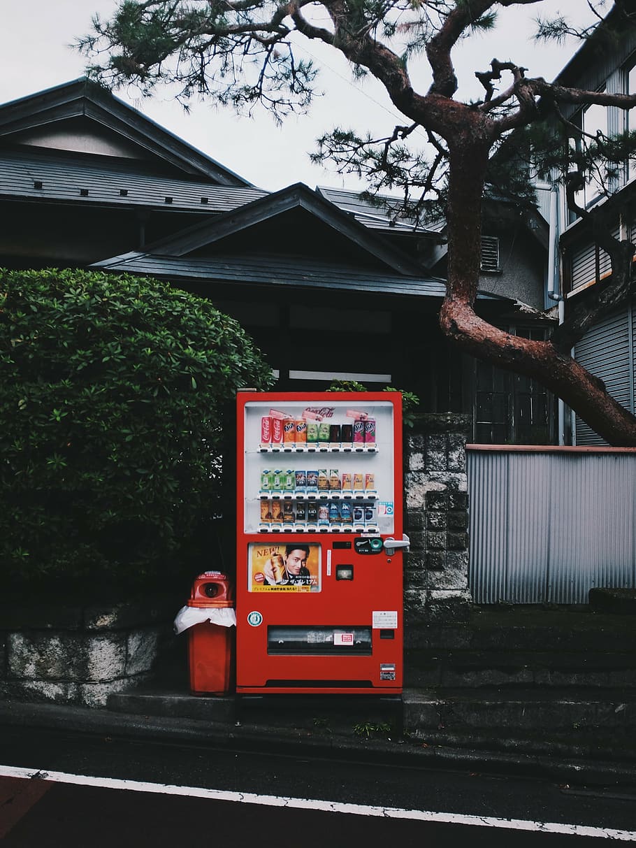 red, beverage vending machine, side, walk, black, tree, near, house, daytime, vendo