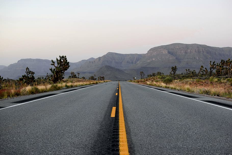 empty highway, asphalt, drive, grass, landscape, mountain, nature, road, sky, travel