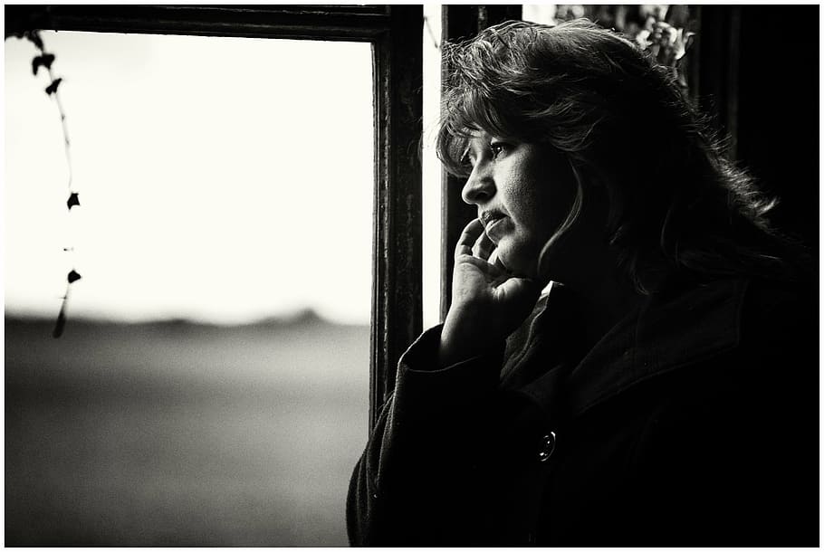 grayscale photo, woman, looking, window, solitude, loneliness, portrait, black and white, thoughtful, sadness