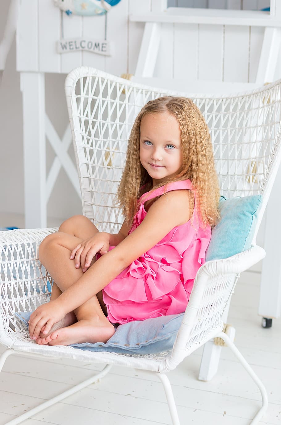 girl, pink, sleeveless dress, sitting, white, wicker armchair, young, blue eyes, eyes, look