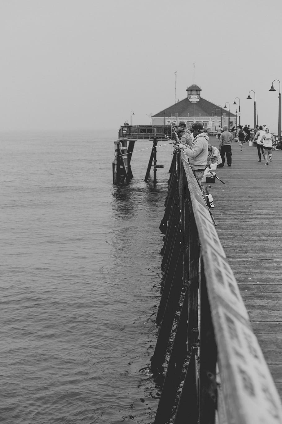 grayscale photo, people, dock fishing, daytime, pier, pathway, ocean, sea, water, travel