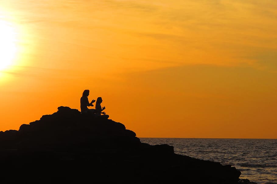 silhouette photo, two, people, sitting, rock, facing, body, water, yoga, sunset