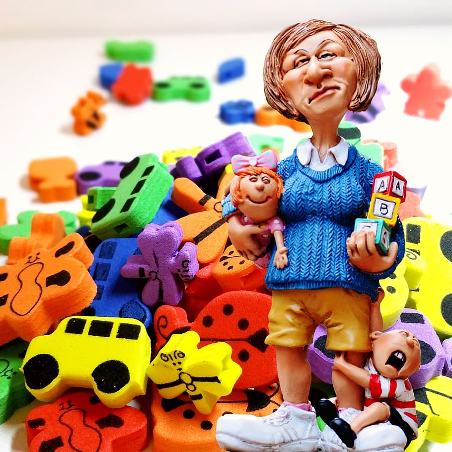 mujer, portador, bebé, al lado, figurita de niño, juguetes de espuma de colores variados, niñera, educador de niños, juguetes, cuarto de niños