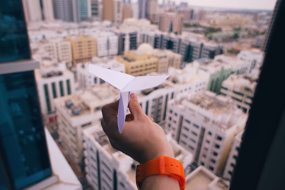 paper, airplane, hand, building, watch, window, architecture, infrastructure, city, towers
