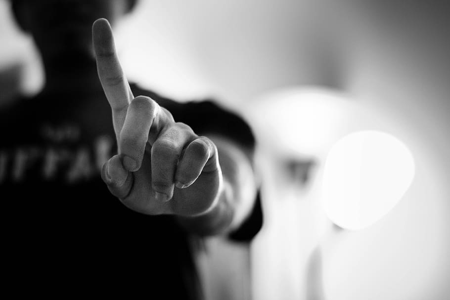 grascale photography, person, black, top, standing, light, photography, black top, finger, pointing