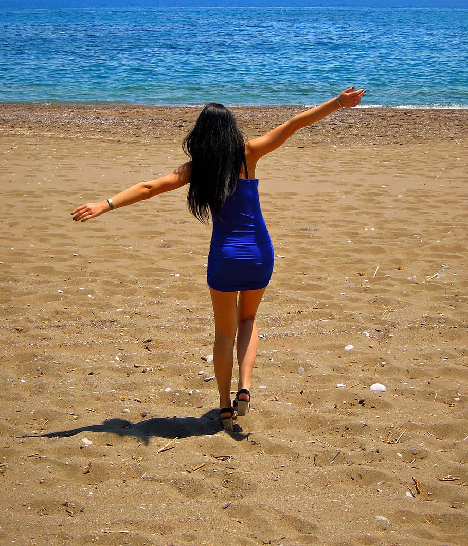 woman, wearing, blue, sleeveless, top, opening, hands, walking, towards, sea