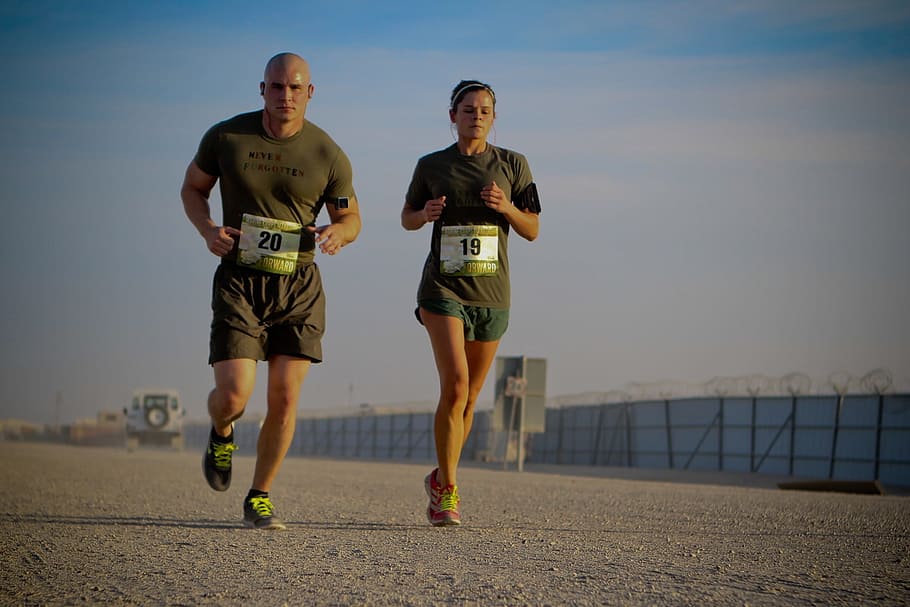 man, woman, green, shirt, shorts, running, daytime, man and woman, on road, wall