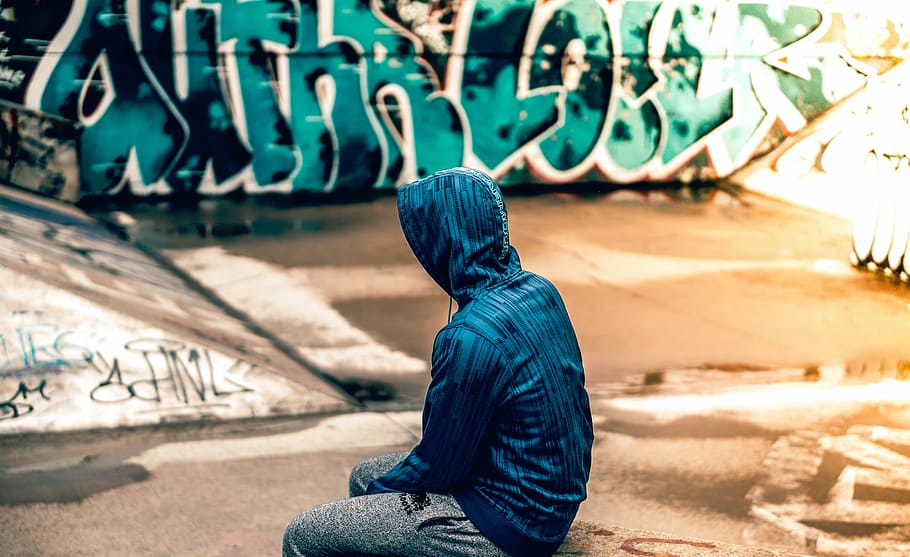man, wearing, blue, hoodie, sitting, skateboard ramp, people, skate, park, wall
