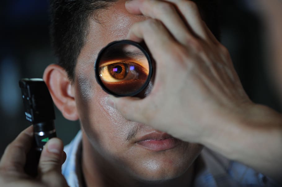 closeup, man, showing, eye, magnifying, glass, optometrist, doctor, patient, exam