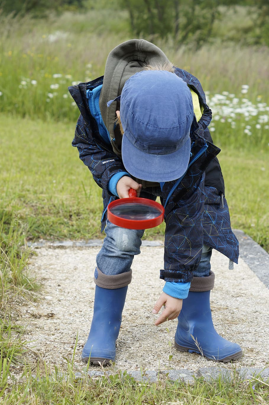 child, wearing, blue, jacket, hat, boots, holding, magnifying, glass, detective