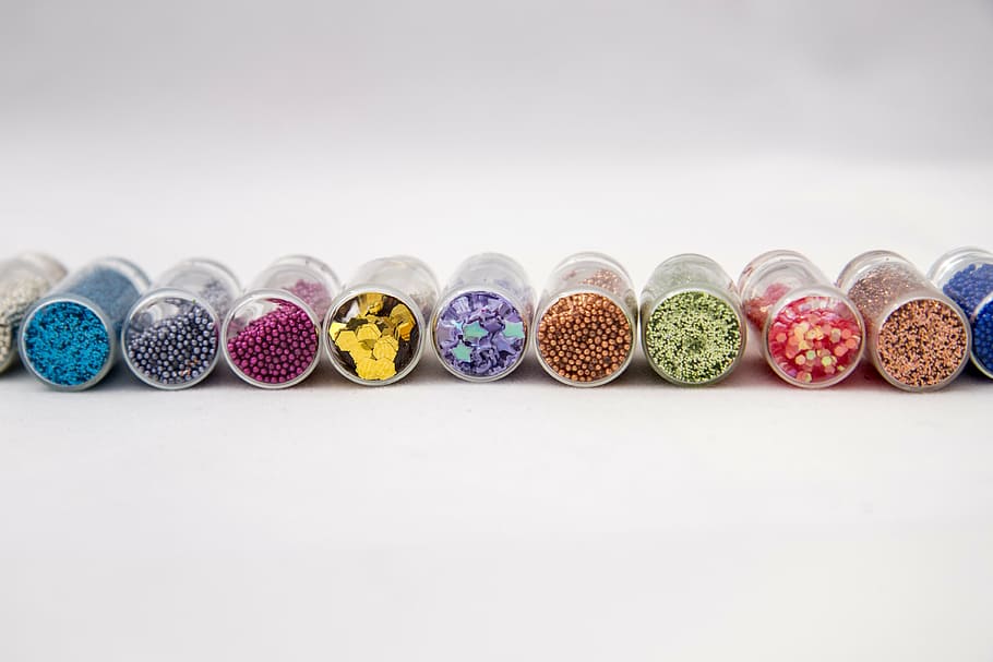 assorted-color bead containers, jars, tinsel, capacity, manicure, ornament, jewelry, light background, beads, bijouterie